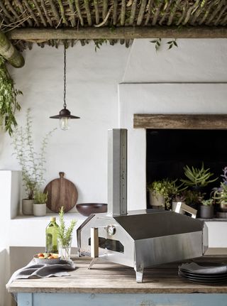 a tabletop pizza oven in an outdoor kitchen