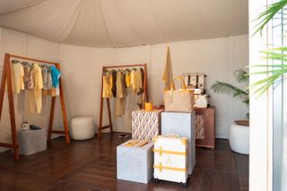 Overview of the retail space inside the Aman cabana, where rails display summer clothing