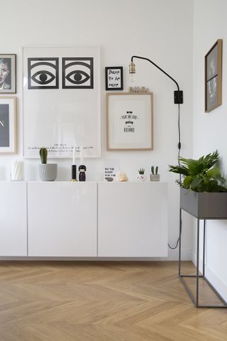 Shot of a white sideboard with a gallery wall hung above with a monochrome theme