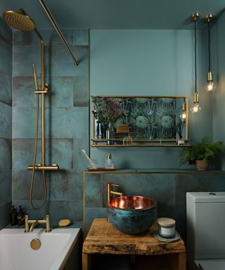 A blue bathroom with gold hardware