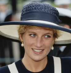Princess Diana wearing a navy and white hat and matching outfit