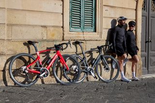 A male and female cyclist standing next to their Pinarello X road bikes