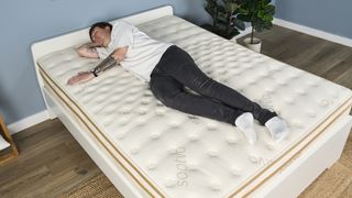 Jack, a mattress deals writer at Tom's Guide, sleeps on his side on the Saatva Classic during a pressure relief test