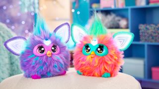 Two new Furby toys sit next to one another on a table