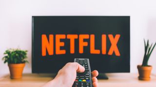 Netflix på en TV-skjerm det pekes en fjernkontroll mot.