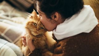 woman kissing cat