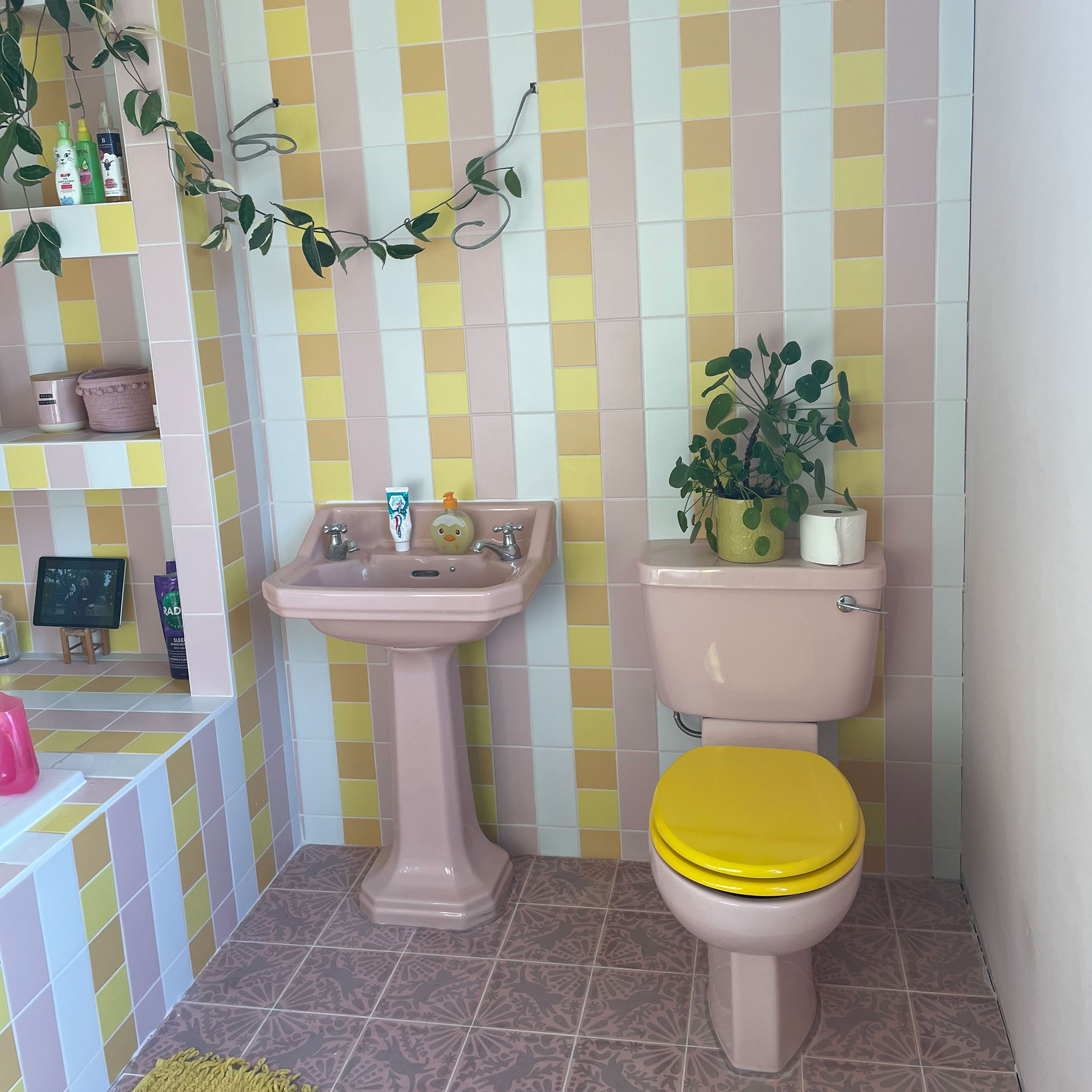 Bathroom with floor and wall tiles in pink, yellow and white