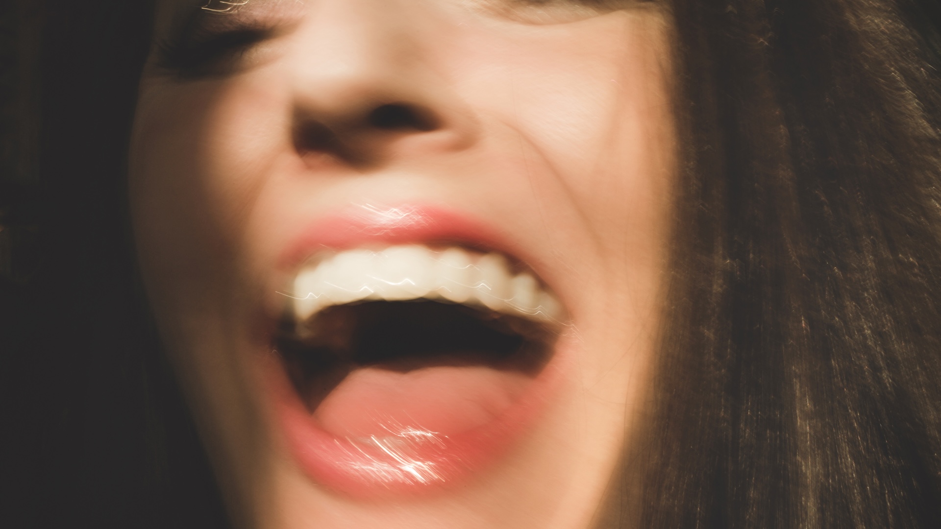 a close-up blurry photo of a woman laughing