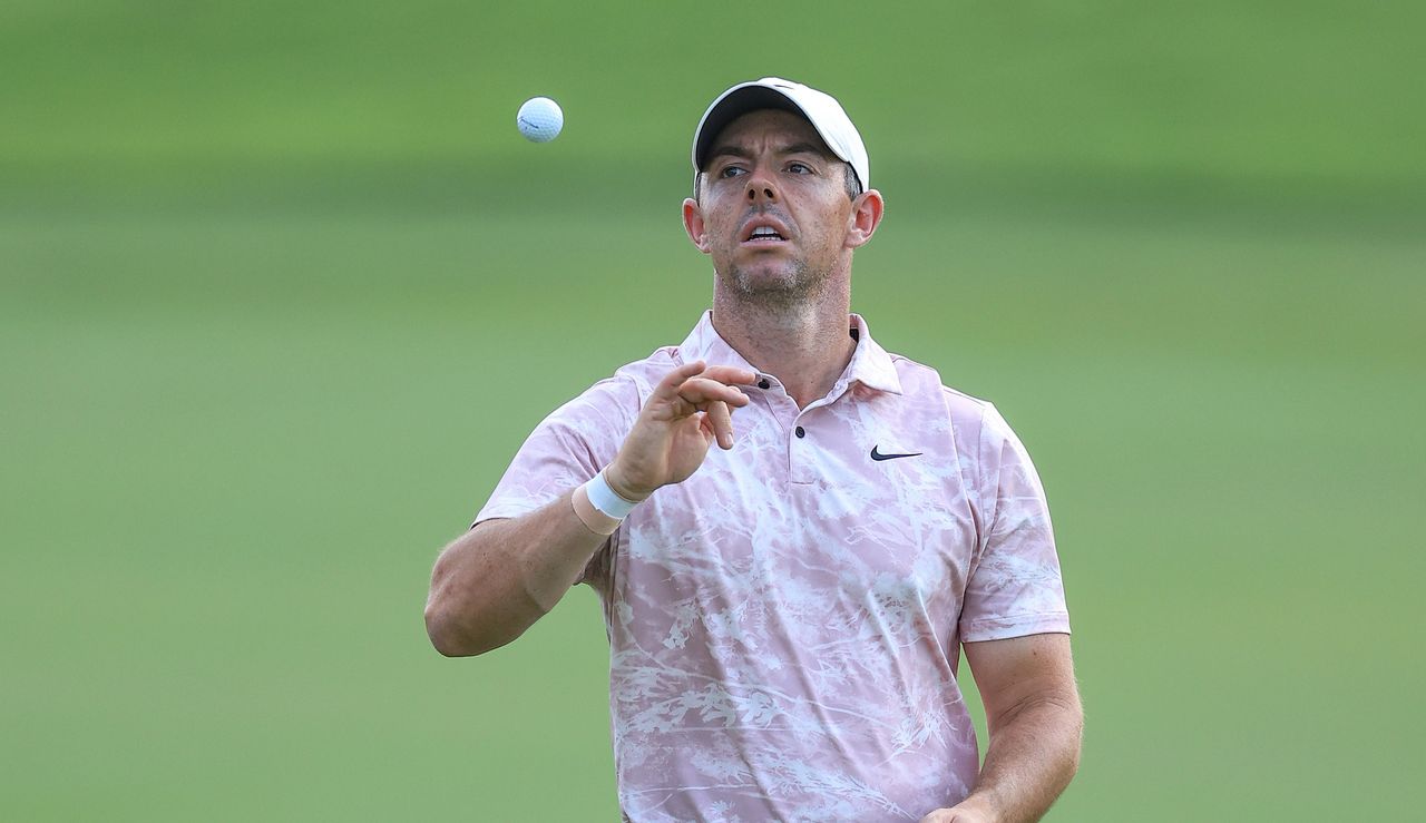 Rory McIlroy throws his golf ball in the air and catches it