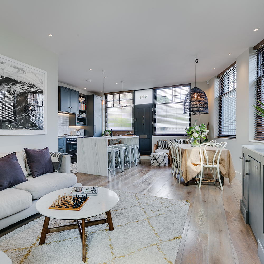 living room with white wall wooden flooring white sofa with cushion