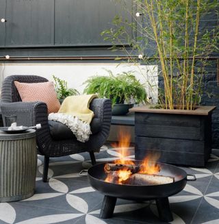 garden area with lay patterned tiles patio and arm chair and fire place