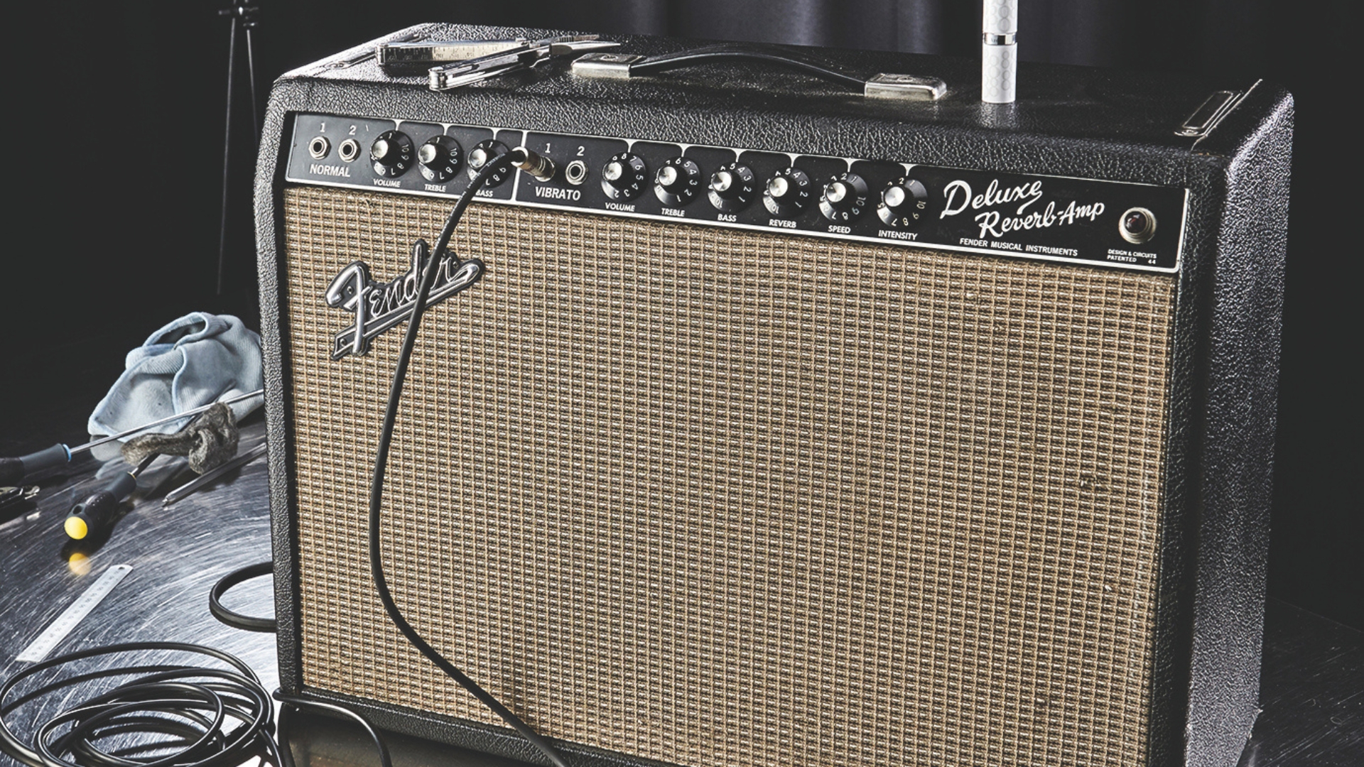 A Fender &amp;lsquo;65 Deluxe Reverb combo amp with various tools around it