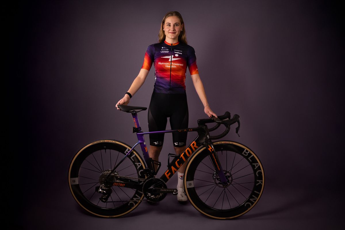Human Powered Health riders pose in new 2026 team kit, a blend of purple and orange