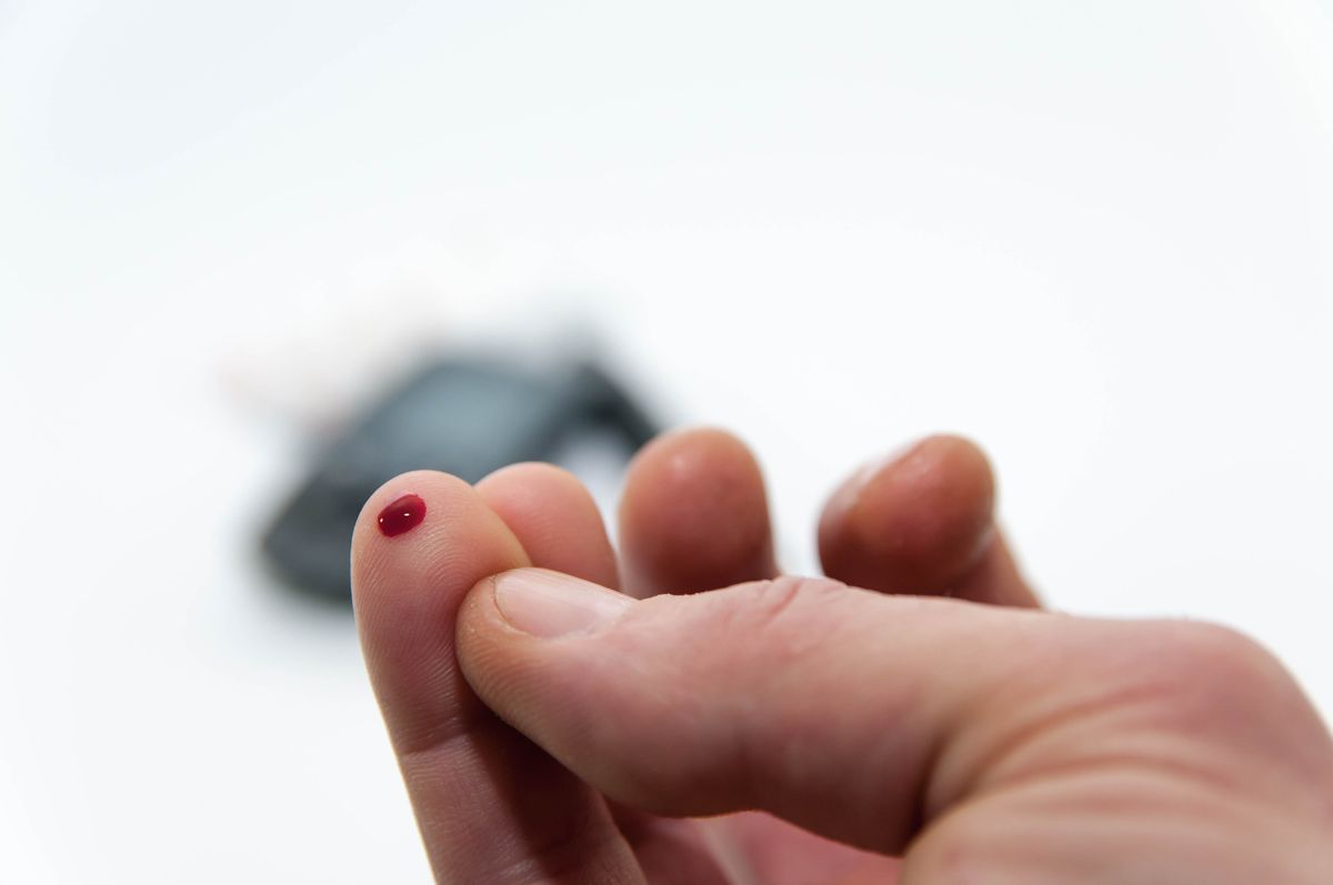 A man pricks his finger to measure his blood sugar level.