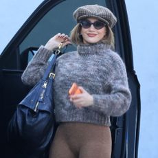 Jennifer Lopez wears a marl knit jumper with brown marl leggings and a knitted baker boy hat.