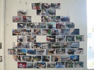 Lots of photographs have been hung on the wall in a brick formation