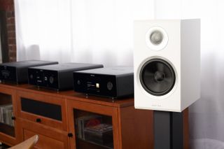 Rotel Amora 5 standmount speakers in white next to a hi-fi system
