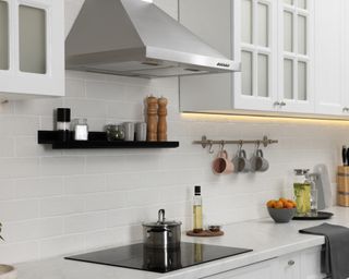 White kitchen with silver range hood