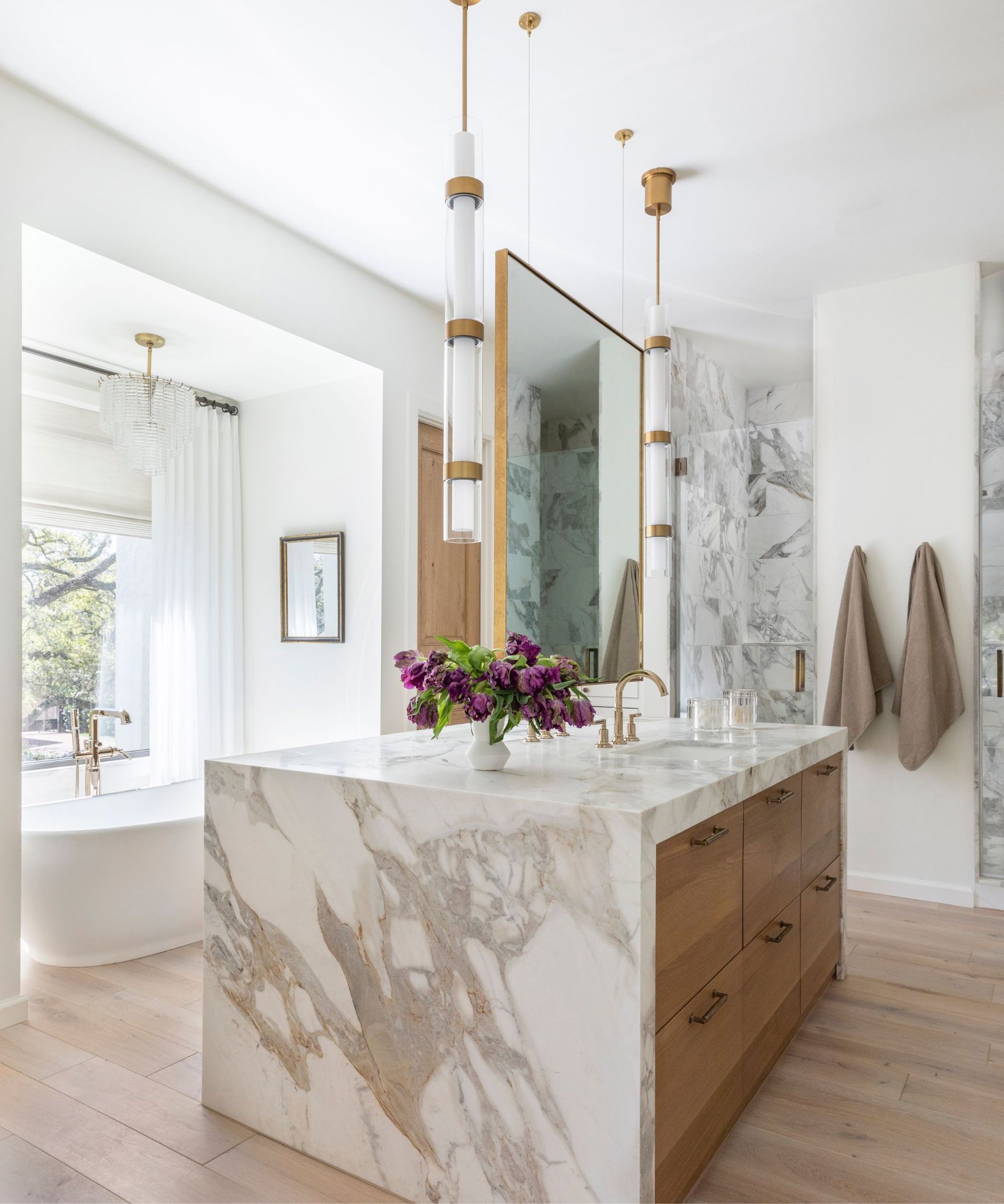 A wood, marble, and white bathroom with a vanity island