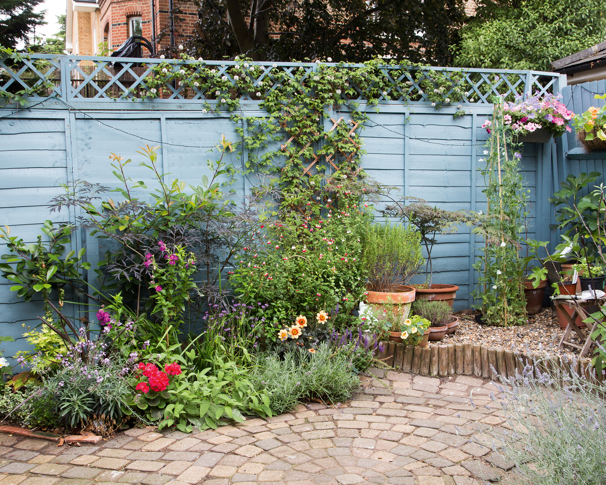 fence painted blue and brick patio