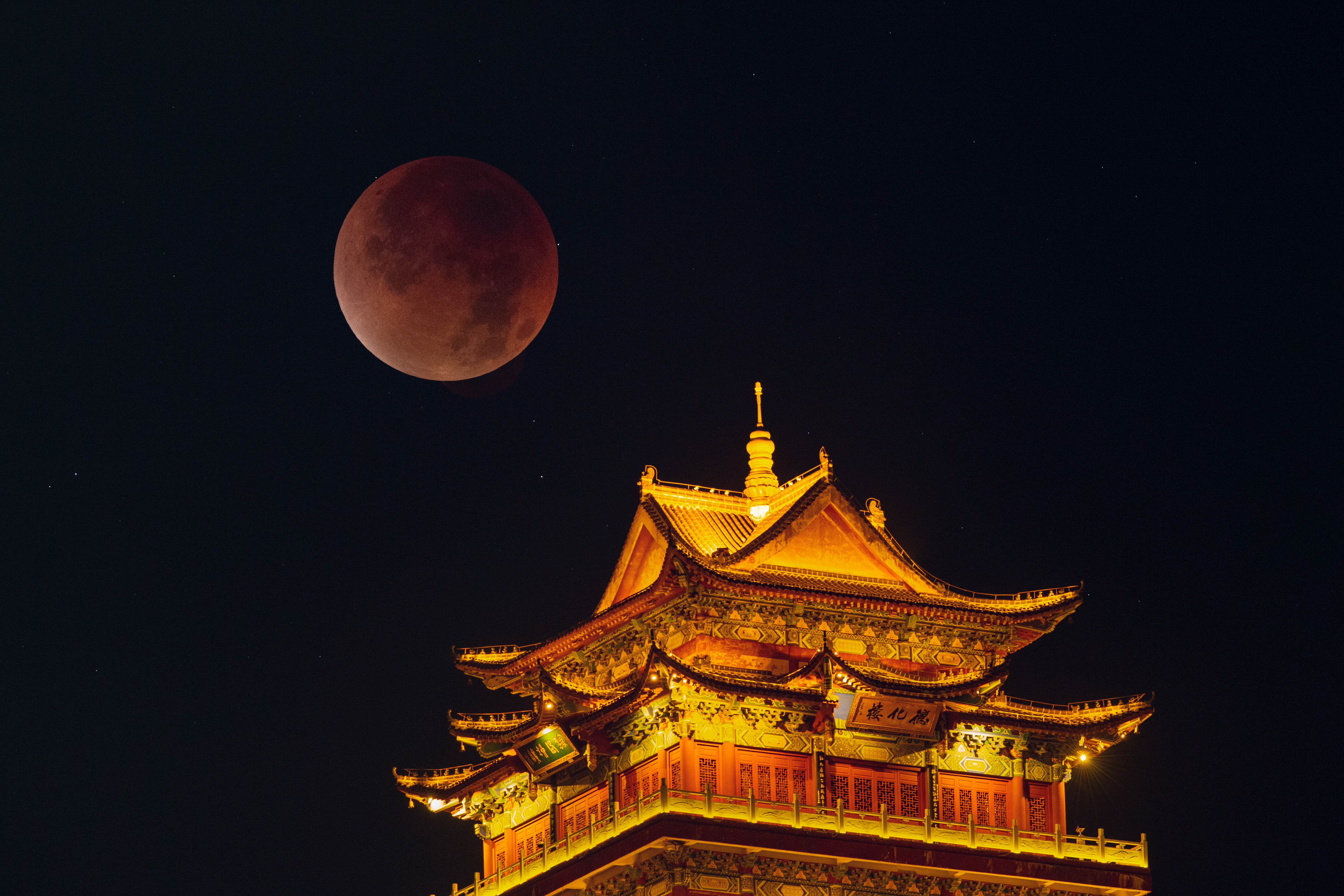 A double exposure photograph of the &quot;blood moon&quot; above a temple in Jiujiang, China.