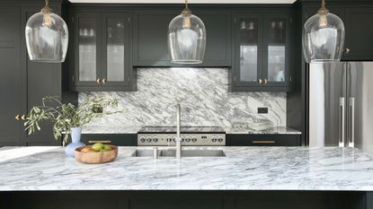 modern monochrome kitchen with marble island, glass pentdant lighting and silver tap