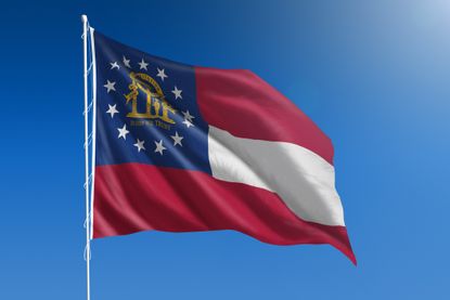 Picture of the Georgia U.S. state flag flying on a pole for Georgia state tax guide