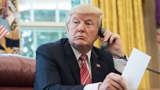 Trump takes a phone call in the Oval Office. 