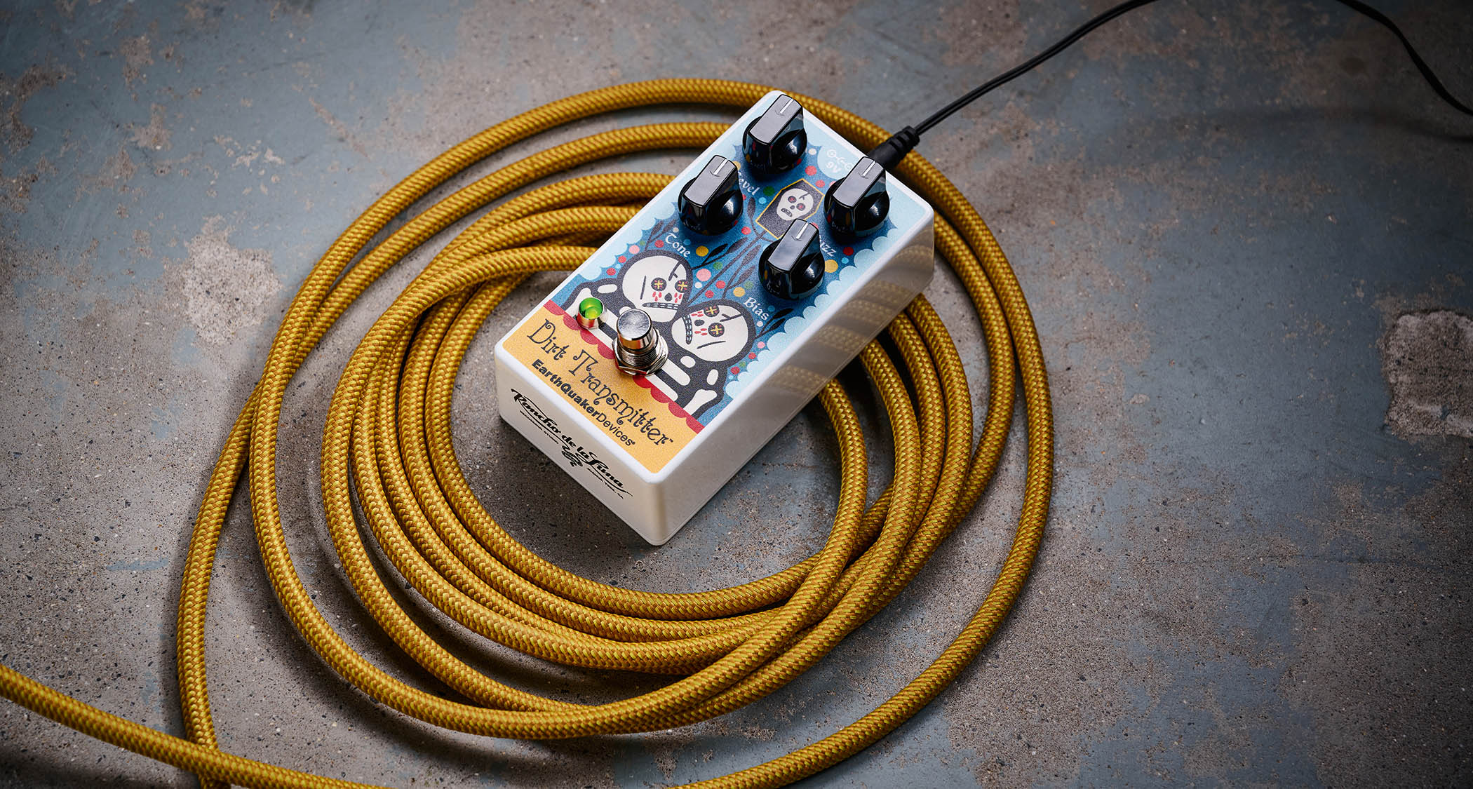EarthQuaker Devices Rancho de la Luna Dirt Transmitter Fuzz Driver photographed on top of a tweed yellow guitar cable.