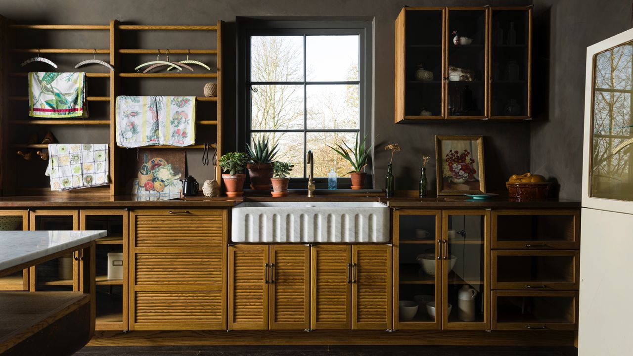 brown kitchen cabinet kitchen with wood cabinets, fluted sink, brown walls, open shelving, glazed lower cabinets 