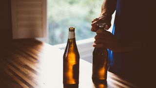 person opening bottle of beer