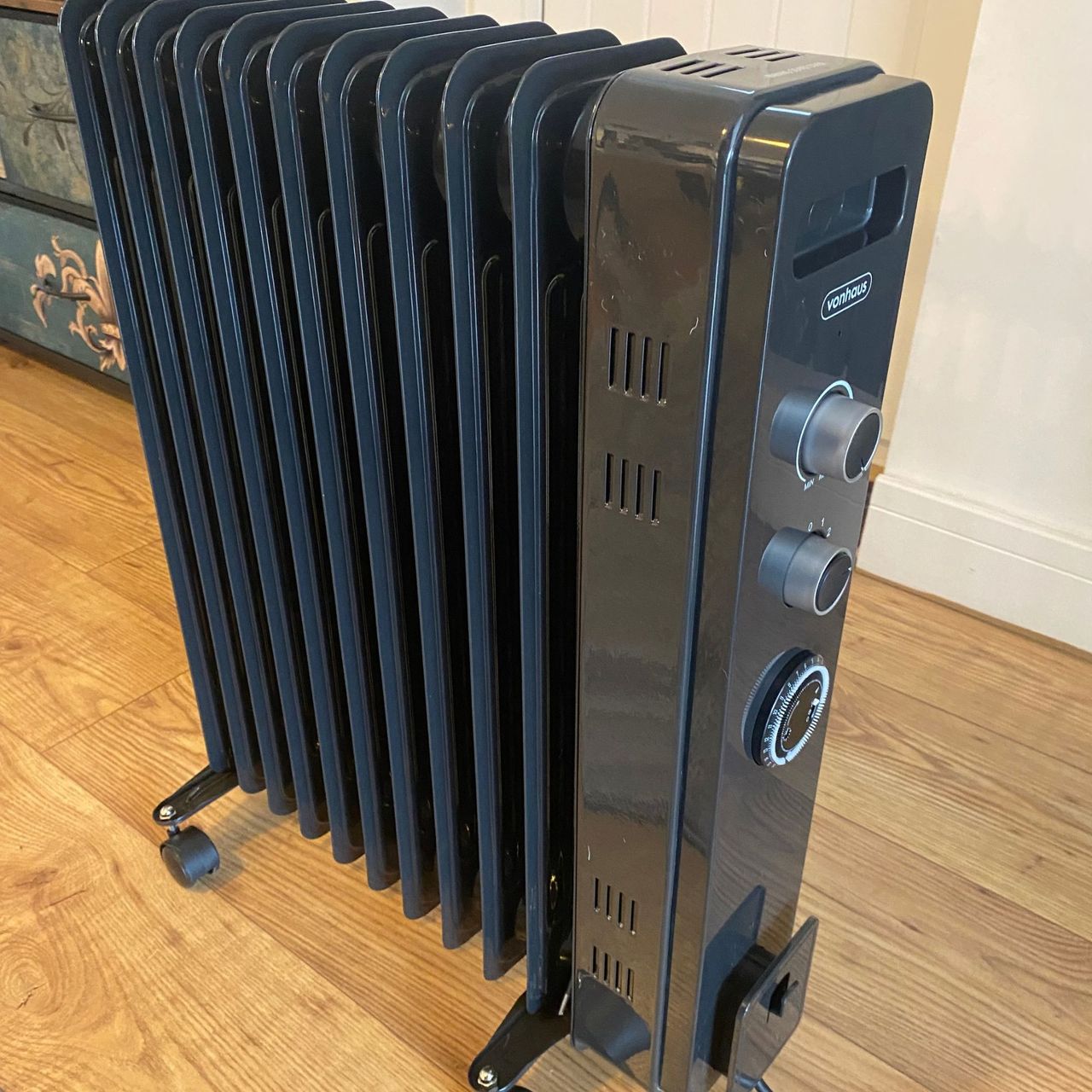 Side view of the Vonhaus 2500W 11 fin oil-filled radiator on a wood-look floor