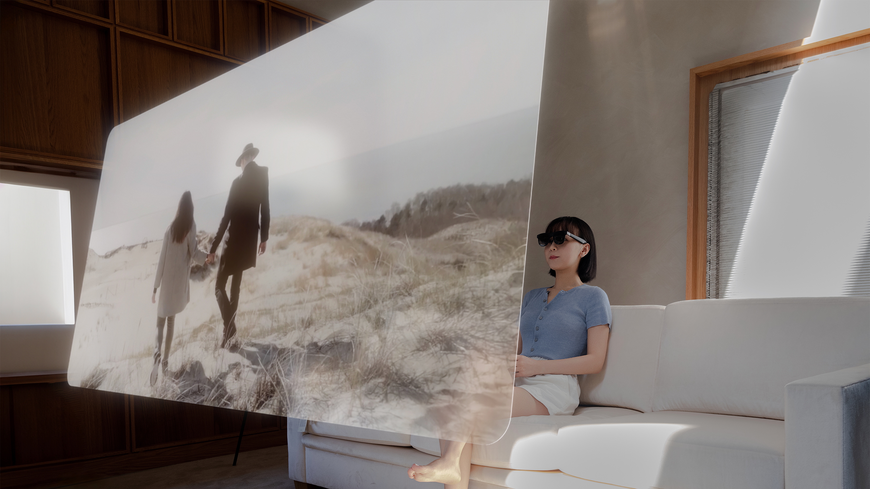 A woman watches a movie on a virtual screen on the Xreal One smart glasses