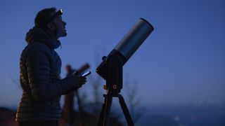 Man using phone to see with smart Unistellar telescope after Nikon announcement