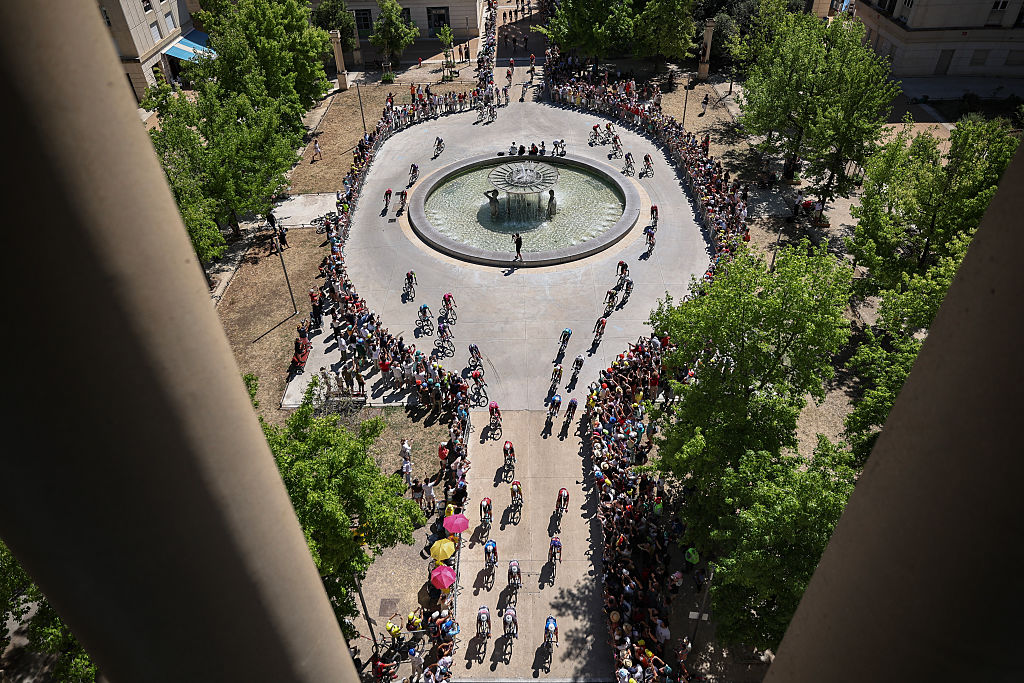 The pack of riders (peloton) cycles across Place de Thessalie in central Montpellier at the start of the 16th stage of the 112th edition of the Tour de France cycling race, 171.5 km between Montpellier and Mont Ventoux, southern France, on July 22, 2025. (Photo by Anne-Christine POUJOULAT / AFP) (Photo by ANNE-CHRISTINE POUJOULAT/AFP via Getty Images)