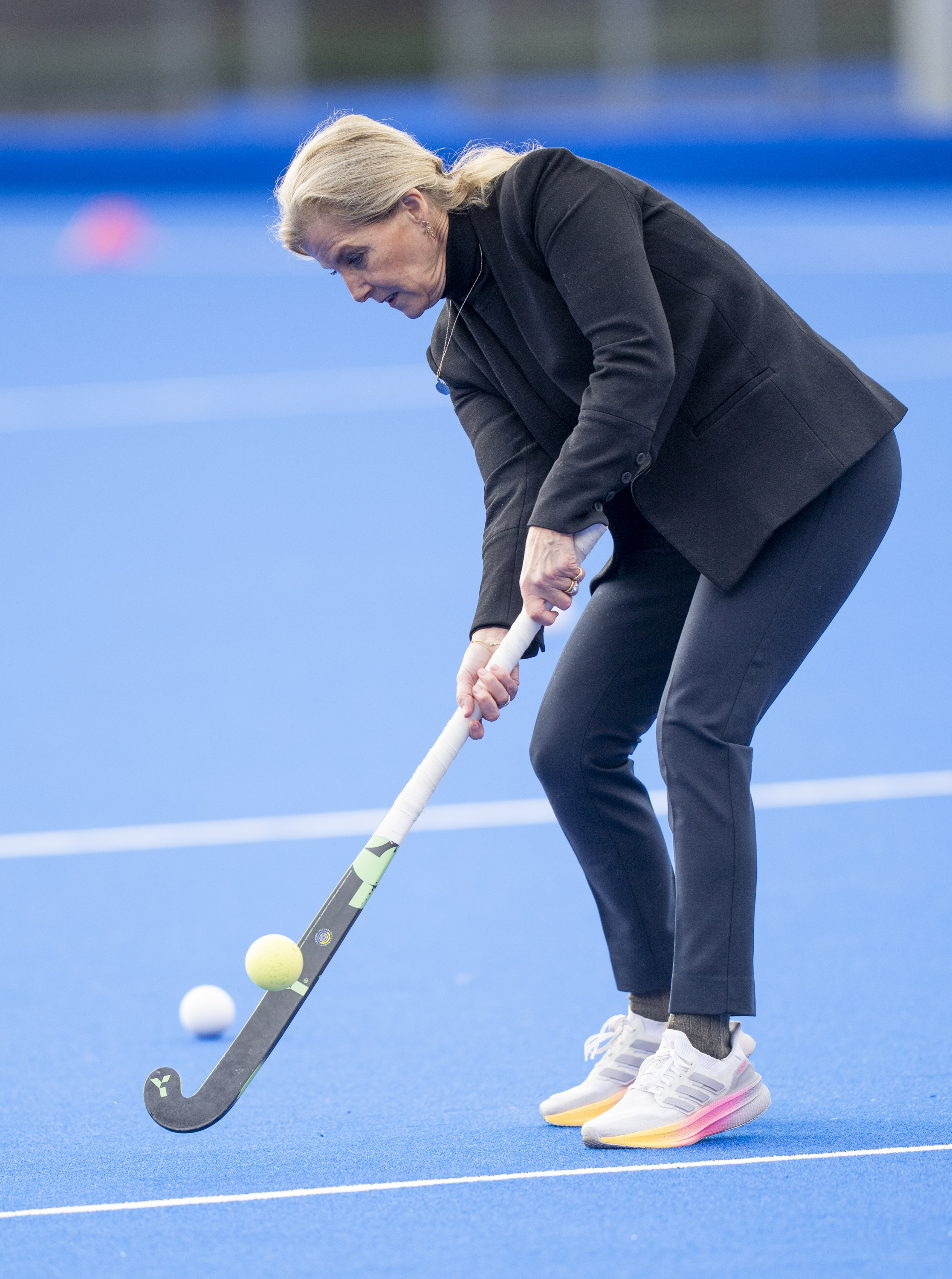 Duchess Sophie playing hockey in a blazer, jeans and sneakers