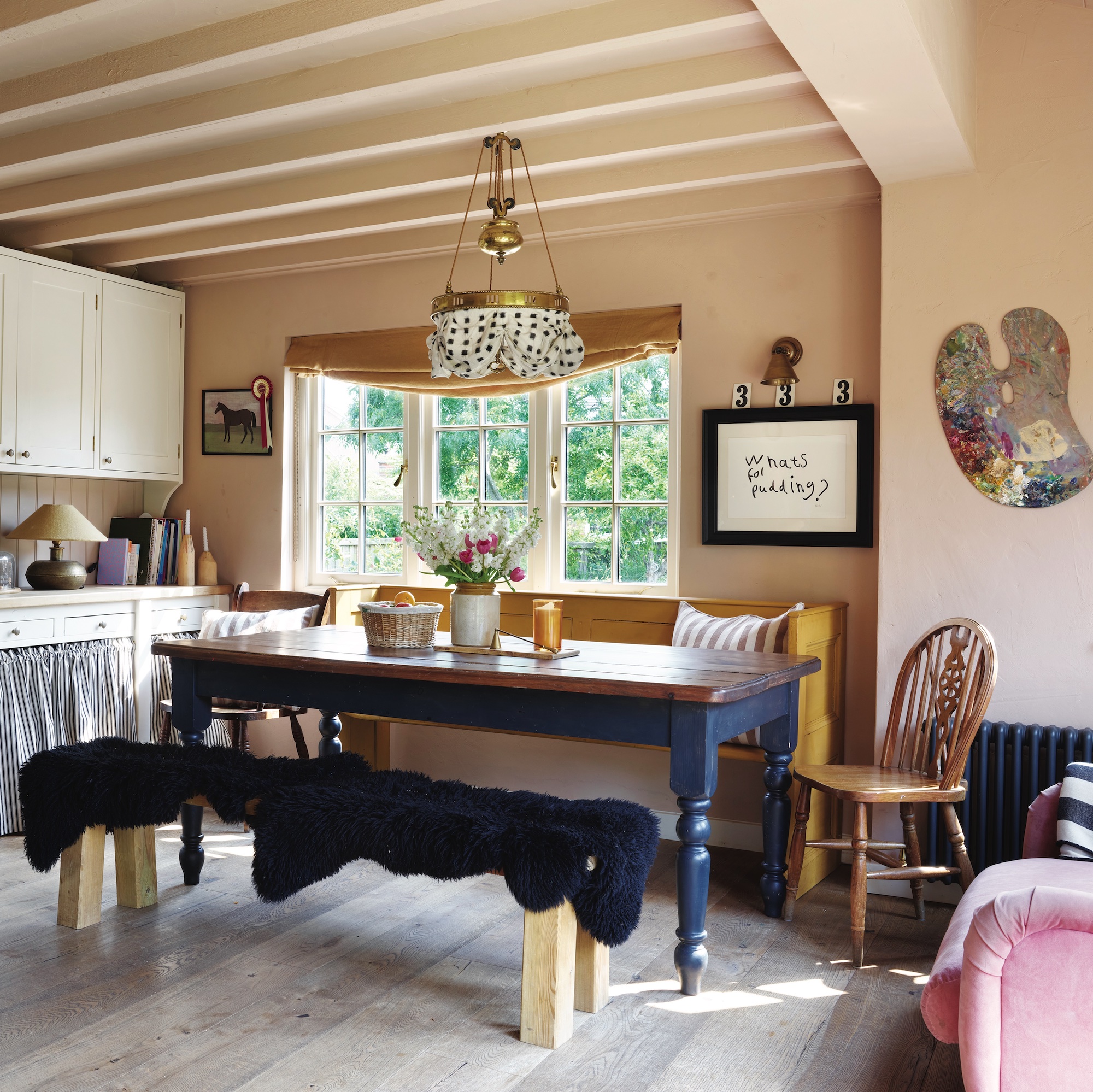 cottage kitchen with farmhouse table and bench covered with navy blue sheepskin