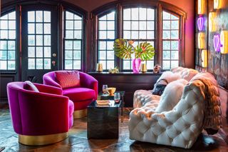 a bold maximalist living room with velvet chairs