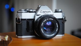 Canon film camera sitting on a guitar with blue bokeh balls in the background