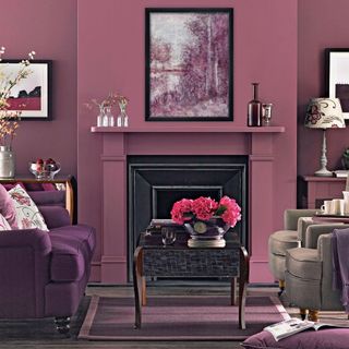 Purple living room with purple velvet sofa and pink flowers on a black coffee table