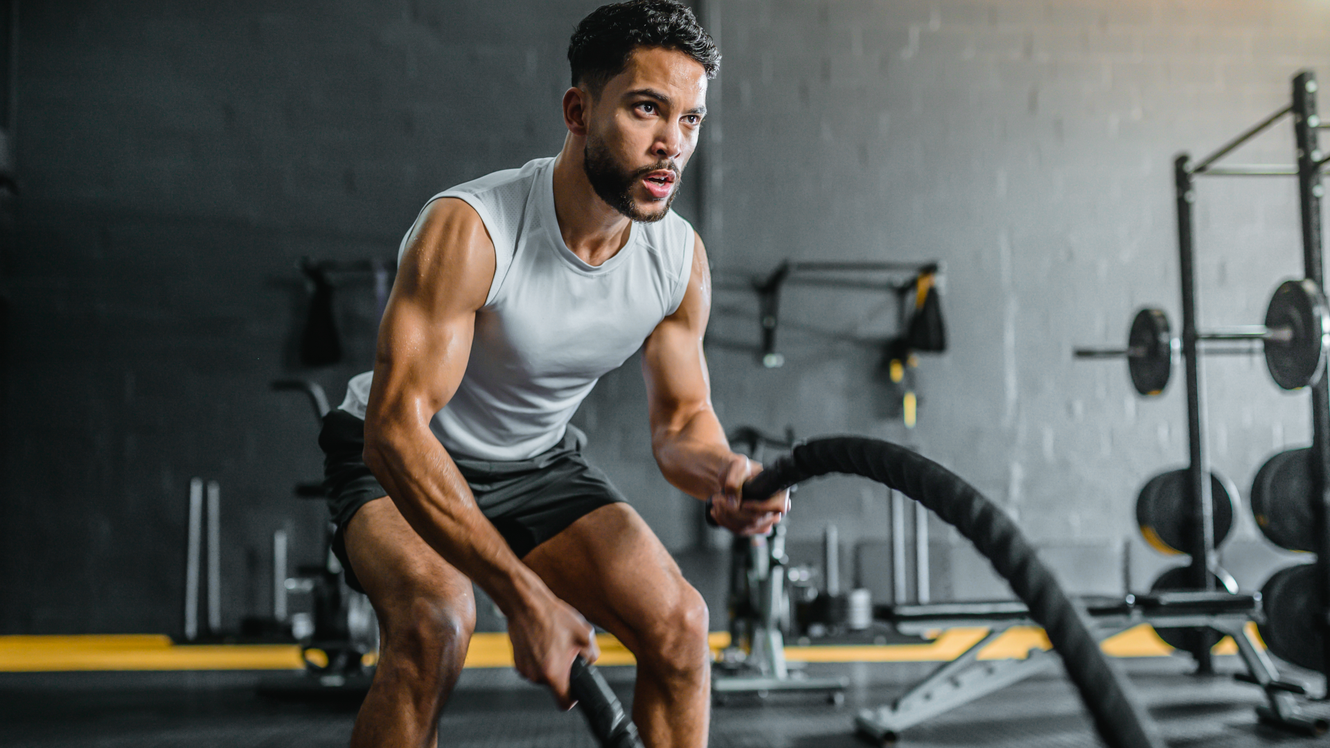A man training with battle ropes at the gym