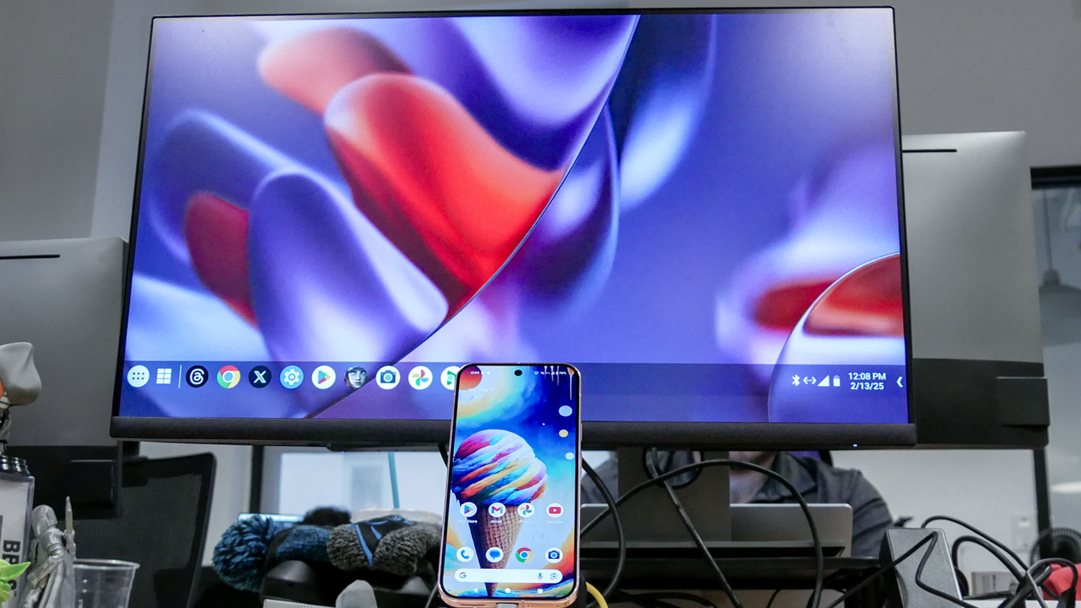 A Pixel 10 phone connected to a monitor showing Google's Desktop Mode on Android
