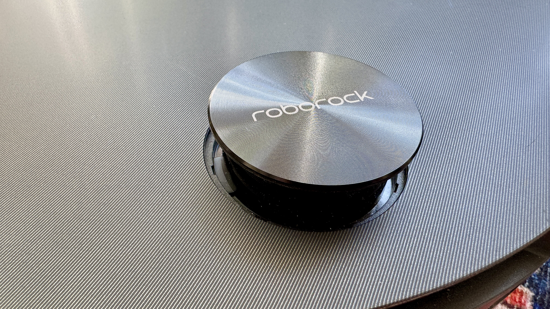Roborock Saros 10 robot vacuum with puck popped up