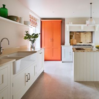kitchen with white wall sink and counter with orange cupboard