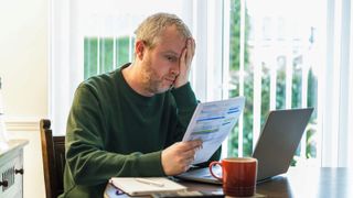 A man checking his energy bills looking worried