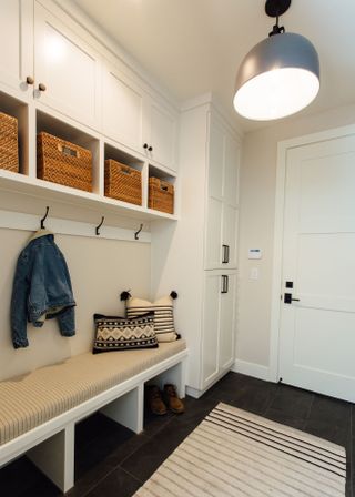 mudroom with white cabinetry and dark floor tile