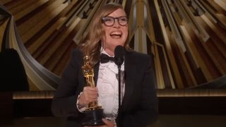 Sarah Polley smiling and holding her Oscar during her acceptance speech at the 2023 Academy Awards.