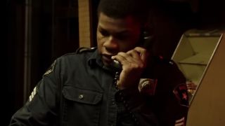 John Boyega on the phone as a part-time security guard in Detroit