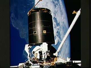 Endeavour's STS-49 crew captures the INTELSAT VI satellite above the shuttle's payload bay.