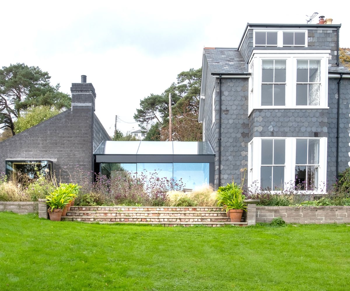 The exterior of a building with a new single storey side extension with a glass link